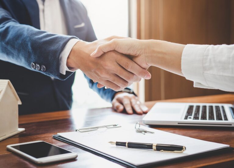 Handshake over property documents symbolising exchange of contracts