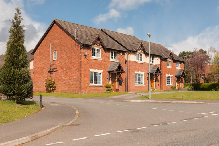 Modern red brick terraced houses with sitting tenants in a quiet suburban street