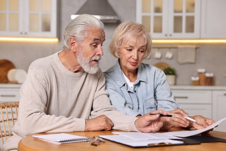 Elderly couple reviewing documents together at home