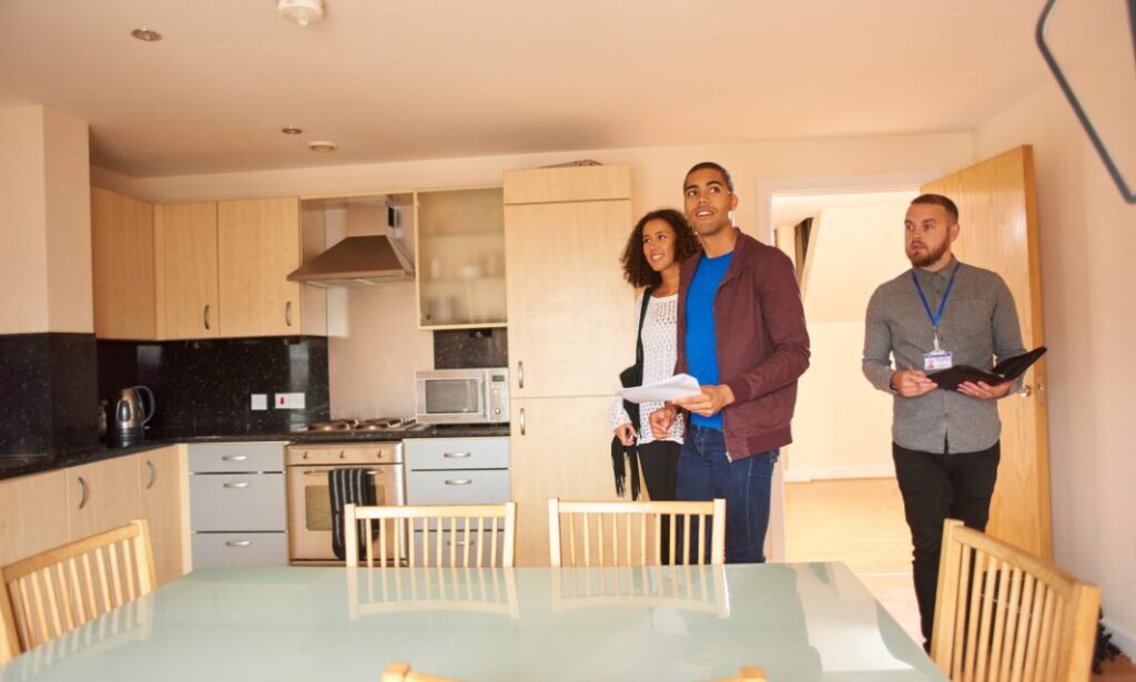 Letting agent handing over house keys to a couple during a rental property handover.”
