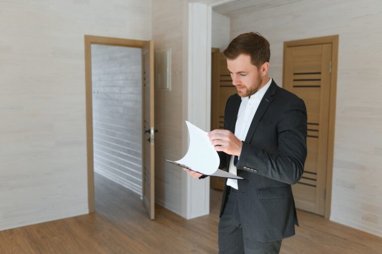 Estate agent reviewing property documents inside an empty house
