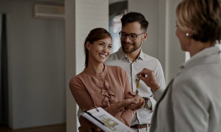 Letting agent handing house keys to new tenants representing landlord management and tenant rights under the Renters Rights Act.