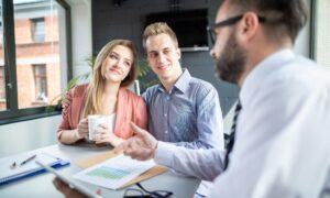 Landlord couple discussing rental documents with letting agent, representing landlord legal help in the UK