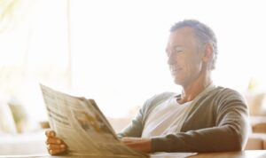 Landlord reading news about the rental bidding ban and new asking rent rules in England