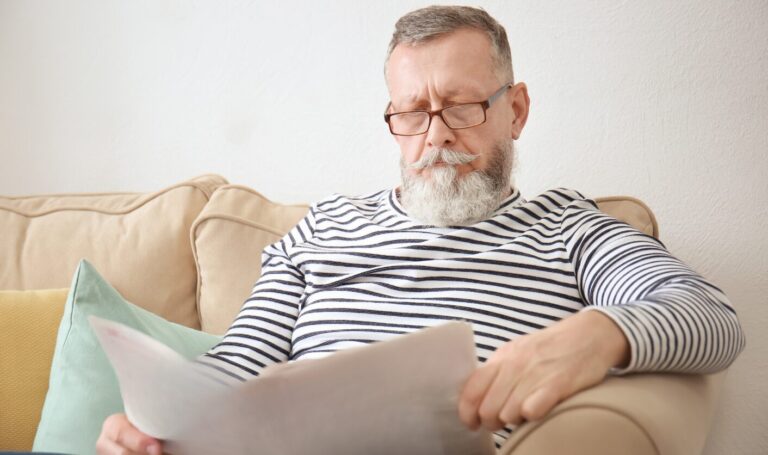 Landlord sitting on a sofa reading tenancy documents while planning to sell a rental property or move back in under the Renters’ Rights Act