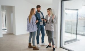 Estate agent explaining property details to tenants in a modern rental home related to the decent homes standard private rental rules.