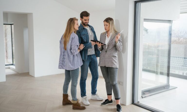 Estate agent explaining property details to tenants in a modern rental home related to the decent homes standard private rental rules.
