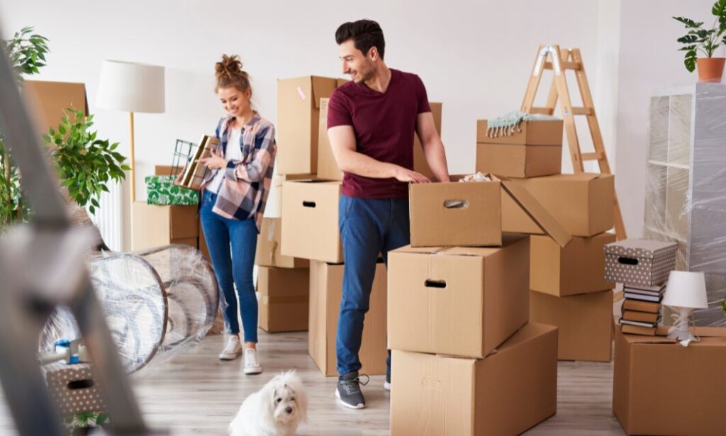 young couple unpacking boxes in a new family home with moving boxes and belongings
