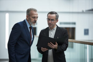 Two professionals reviewing documents together, representing landlord compliance, PRS database registration and property management planning