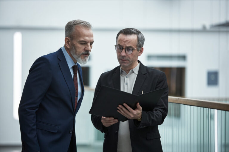 Two professionals reviewing documents together, representing landlord compliance, PRS database registration and property management planning