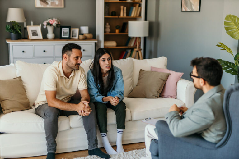 Landlord meeting with prospective tenants in a living room to discuss rent in advance, tenancy terms and compliance requirements