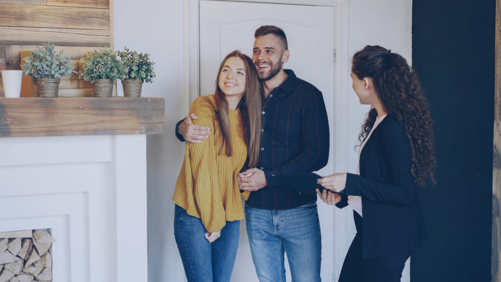 Young couple speaking with a letting agent during a property viewing in Sefton, highlighting professional property management services.