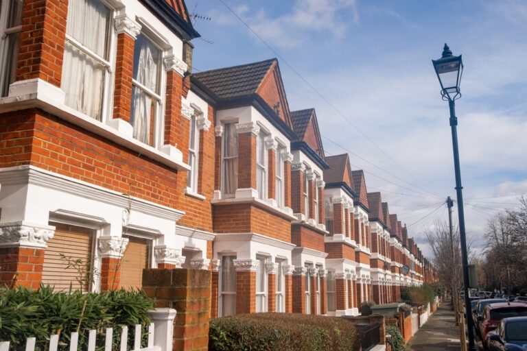 Row of traditional red-brick terraced houses on a UK street