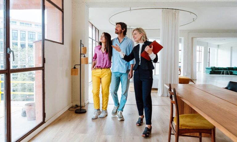 Estate agent showing a couple around a modern apartment, representing Pontefract new build hotspots and buyer demand in 2026.
