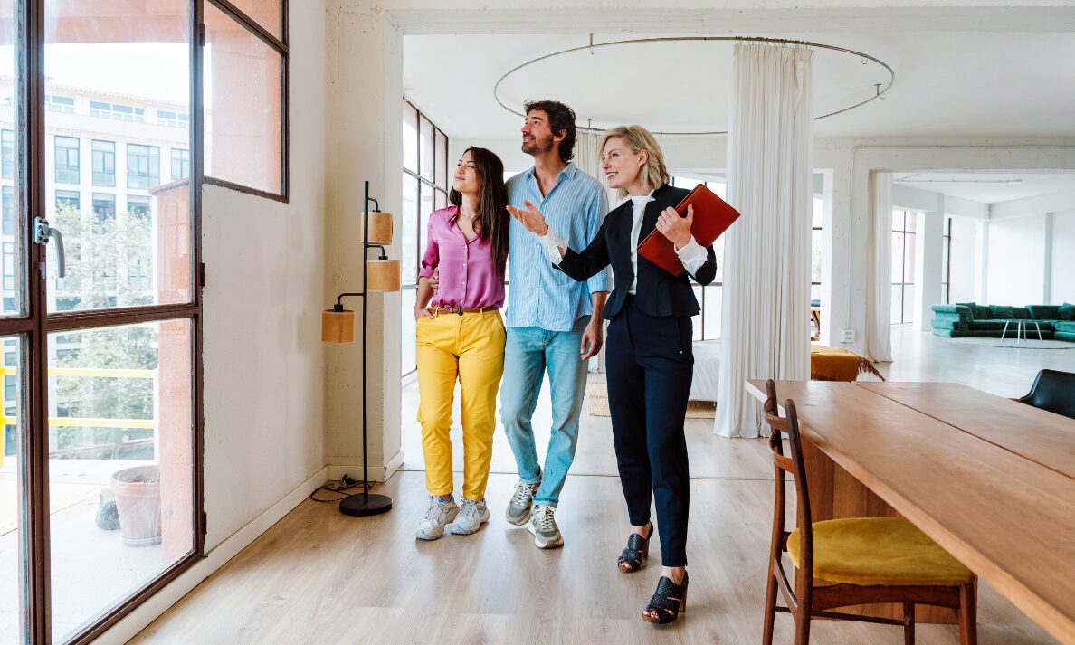 Estate agent showing a couple around a modern apartment, representing Pontefract new build hotspots and buyer demand in 2026.