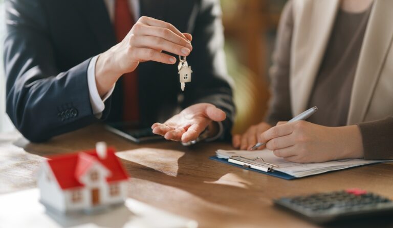 Property agent handing over house keys during short lease agreement