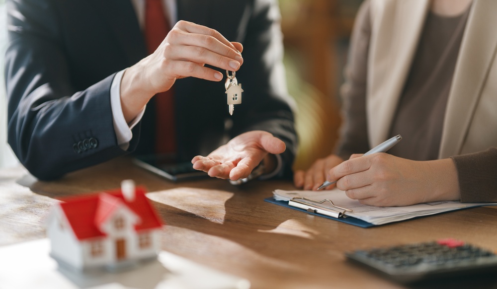 Property agent handing over house keys during short lease agreement