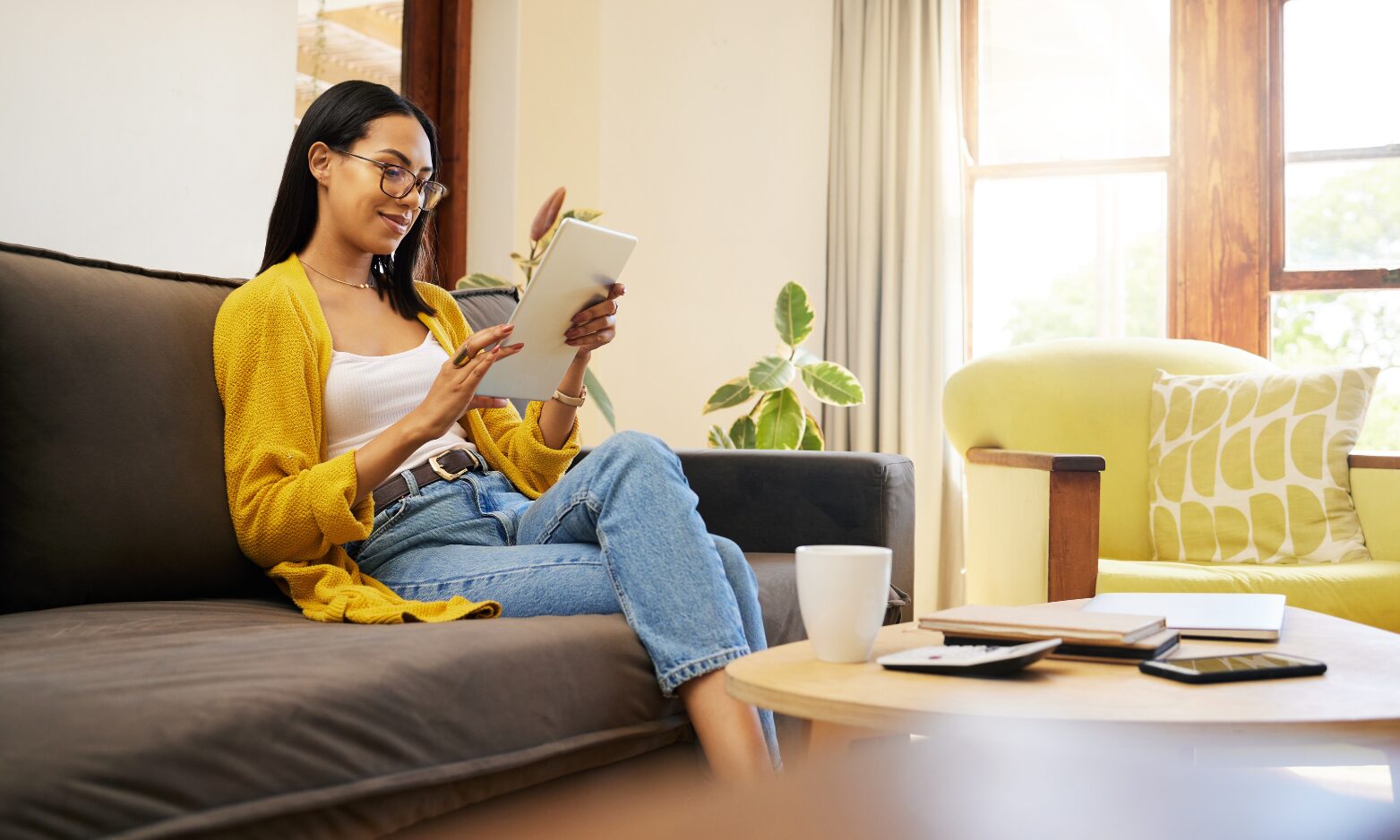 A landlord relaxing at home while reading property management and tenancy legislation updates on a tablet.