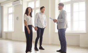Homeowners speaking with an estate agent while viewing a bright residential property.