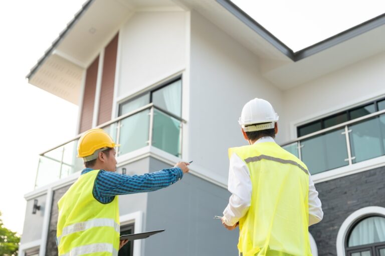 Building surveyors inspecting a modern residential property exterior