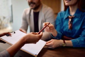 Tenant signing rental agreement with letting agent at office