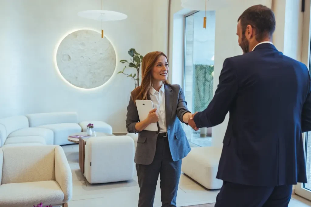 Estate agent meeting a property owner inside a modern home while preparing a Huyton property to let