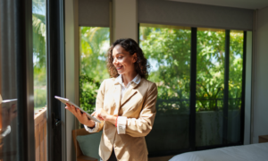 Letting agent using a tablet inside a rental property, representing landlords renting out property in Huyton in 2026.