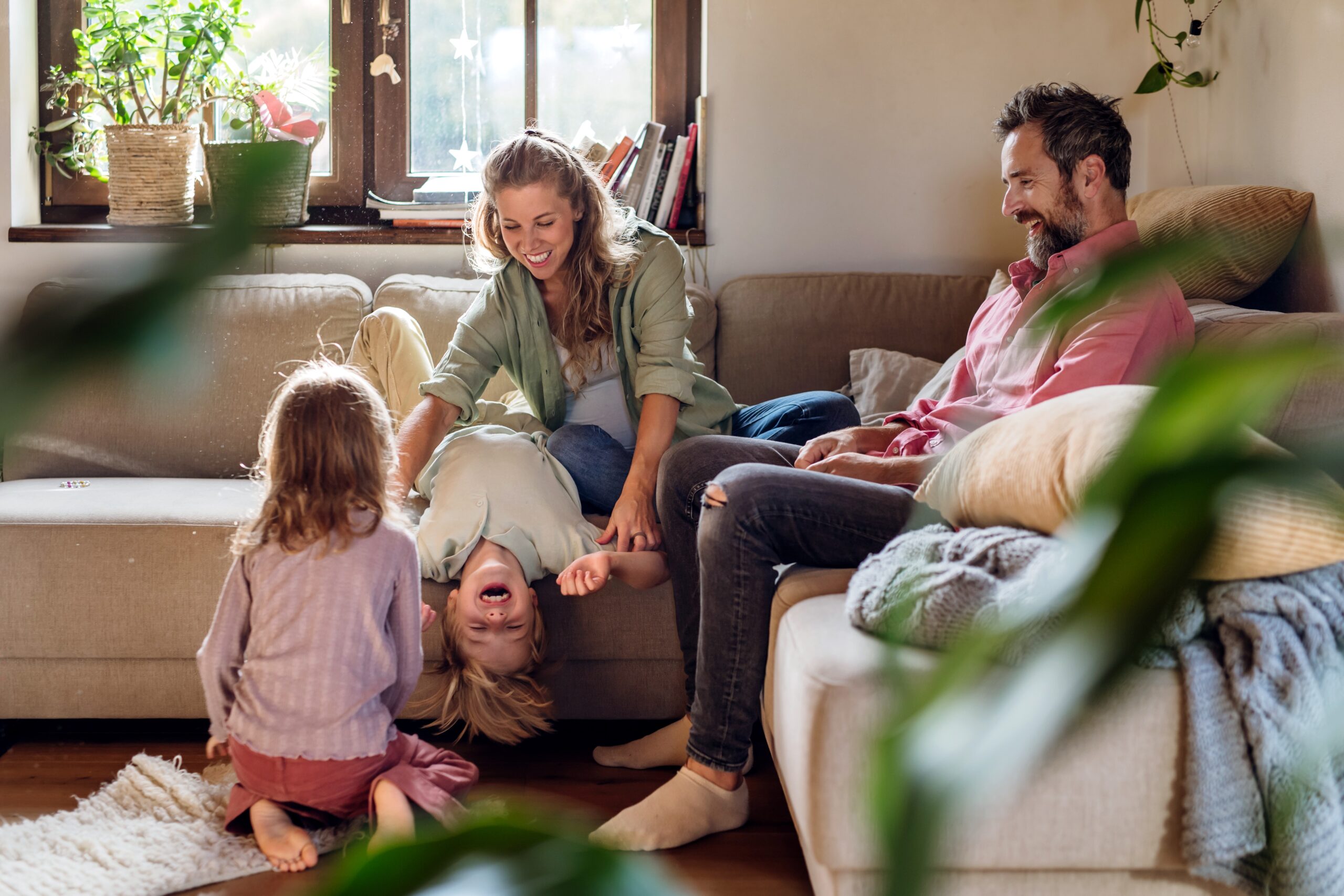 Parents playing with their two young children in a sunny living room, showing family life in Pontefract WF8
